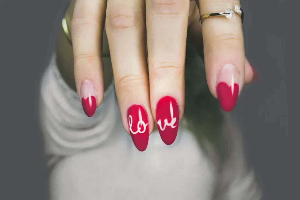 Zbliżenie na dłoń kobiety z różowym manicure, prezentującą zadbane paznokcie.