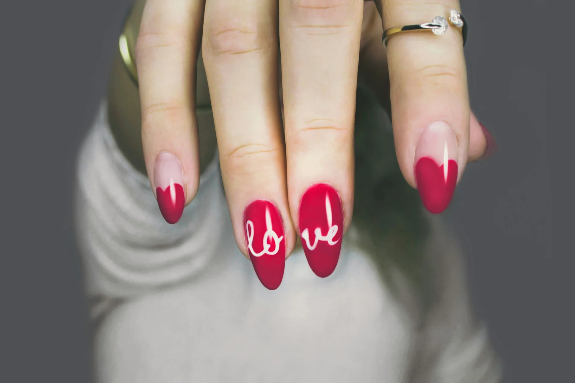 Zbliżenie na dłoń kobiety z różowym manicure, prezentującą zadbane paznokcie.